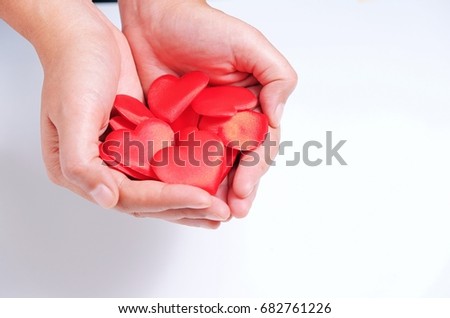 Concept of love, holding red hearts in hand on white background