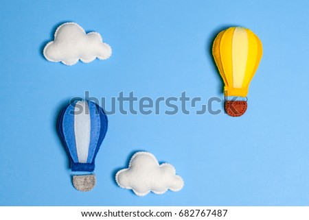 Hot air balloon in blue sky with clouds and copy space. Hand made felt toys.