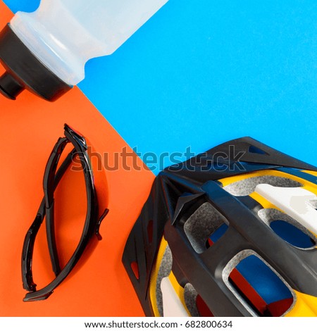 set bicycle equipment on a blue and orange paper background with healthy sports