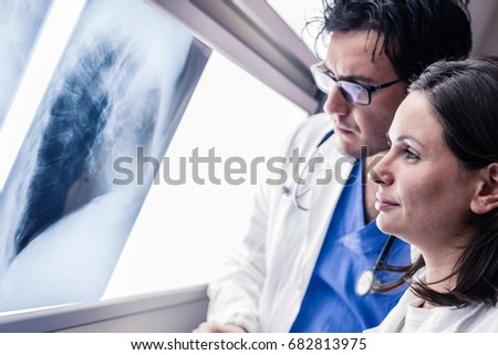 two yound doctors examining a x-ray film at the diaphanoscope