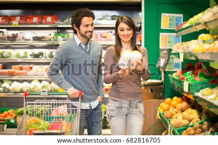 Couple grocery shopping in a supermarket