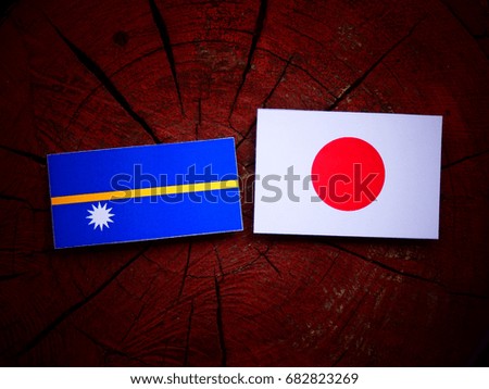 Nauru flag with Japanese flag on a tree stump isolated
