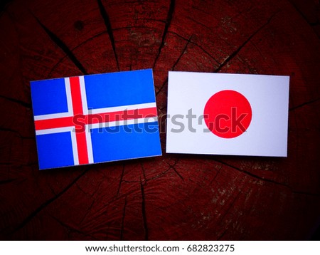 Icelandic flag with Japanese flag on a tree stump isolated