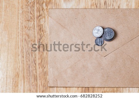 Envelope and coins on wooden background