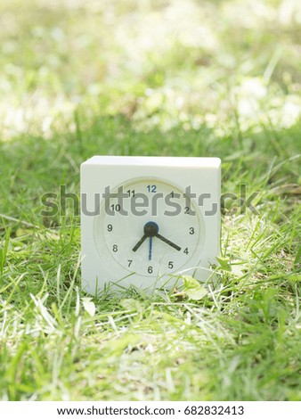 White rectangle simple clock on lawn yard, 7:20 seven twenty
