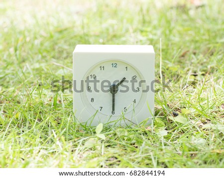 White rectangle simple clock on lawn yard, 1:30 one thirty half