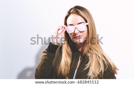 Hipster girl wearing sunglasses on a white background