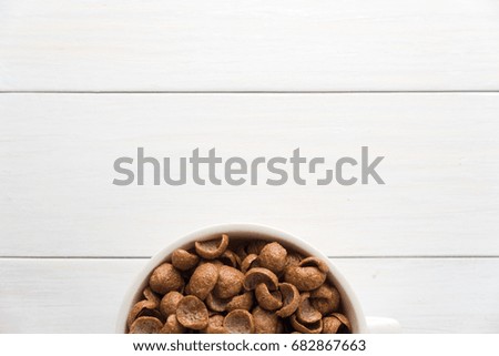 Chocolate cornflakes, Cereal on white wooden table,space for text.