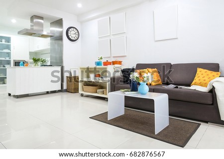 Living room next to kitchen Decorated in a white,minimalist style and decorated by a picture frame,sofa,desk.
