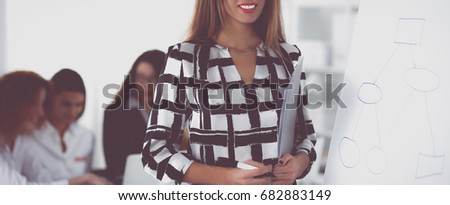 Young woman standing near board with folder
