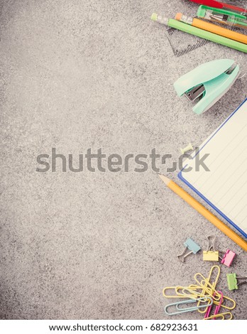 Assorted colorful school supplies on gray stone background. Concept with copy space. Retro style toned.