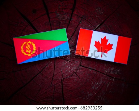 Eritrean flag with Canadian flag on a tree stump isolated