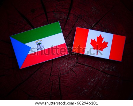Equatorial Guinea flag with Canadian flag on a tree stump isolated