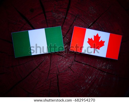 Nigerian flag with Canadian flag on a tree stump isolated