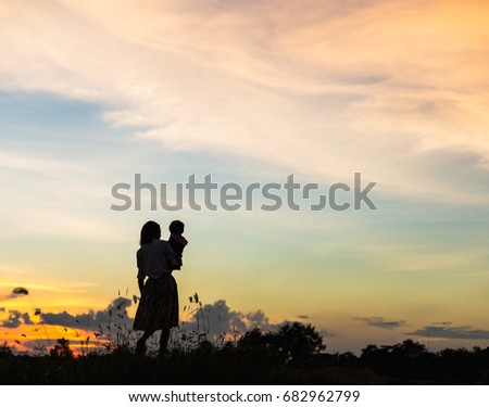 silhouette Happy mother and daughter laughing together outdoors
