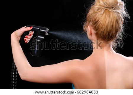 Woman body paint with airbrush in professional beauty salon Royalty-Free Stock Photo #682984030