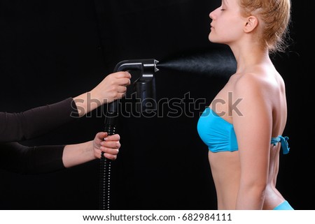 Woman body paint with airbrush in professional beauty salon Royalty-Free Stock Photo #682984111