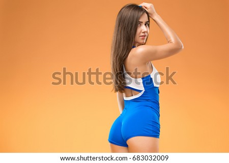 Muscular young woman athlete posing at studio