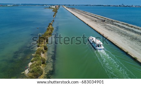Aerial view of boats in canal in lagoon of Mediterranean sea Etang de Thau water from above, travel by barge in South France
