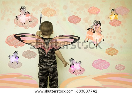 Concept of creativity child. The little boy draws on the wall. Flying cows. Fantasy for children. Photo illustration for your design.