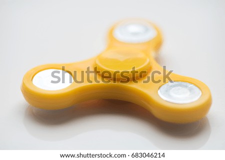 Yellow  hand Spinner. Stress relieving toy on white background. Close-up. Top view. Stock photo