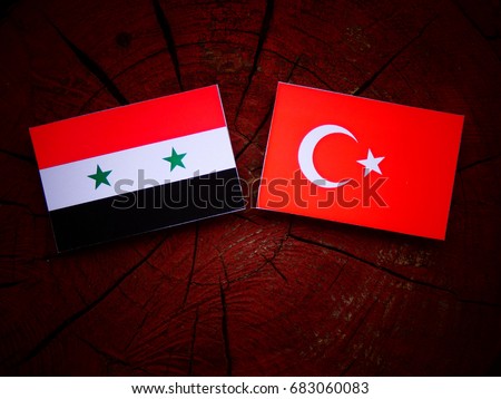 Syrian flag with Turkish flag on a tree stump isolated