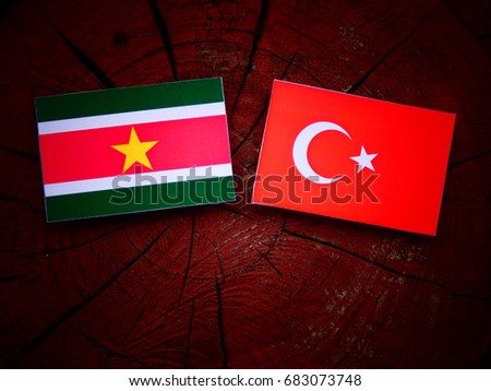 Suriname flag with Turkish flag on a tree stump isolated