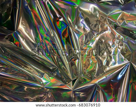 Holographic colorful psychedelic image taken from real foil.Psychedelic or holographic background image. Very bright multicolor texture with all colors of rainbow.surface for luxury shiny metal look  