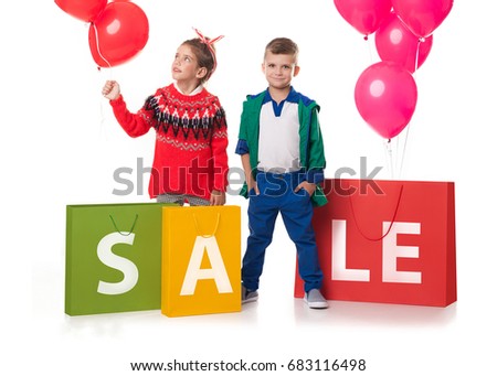 Fashion children with purchases in packages on which SALE is written