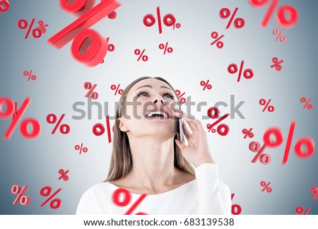 Portrait of a happy, young and beautiful businesswoman talking on a smartphone and looking upwards. Gray background. Percent signs. Double exposrue