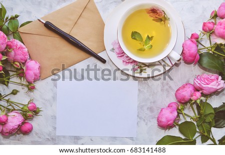 Vintage mockup. Blank paper and envelope, tea cup, pink roses, pen. Wedding invitation