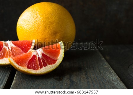 Large ripe grapefruit on an old black background