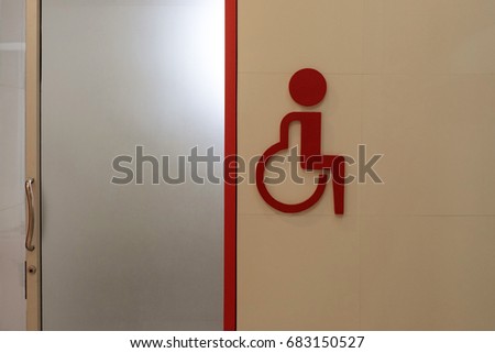 Symbol of person with a disability restrooms on entrance door.