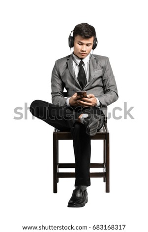 Portrait of an asian business man listen to music on smart phone with headphones. Isolated on white background with clipping path