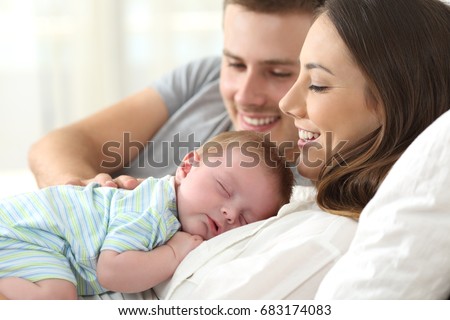 Close up portrait of a happy parents watching their baby sleeping on a bed at home Royalty-Free Stock Photo #683174083