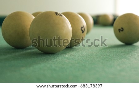 Russian billiards  white balls, yellow cue ball, wooden cue on a large table with green cloth