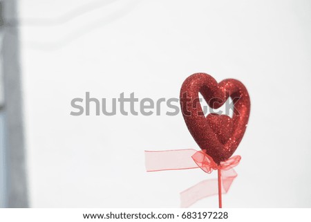 Closeup on red love heart over light background