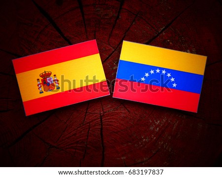 Spanish flag with Venezuelan flag on a tree stump isolated