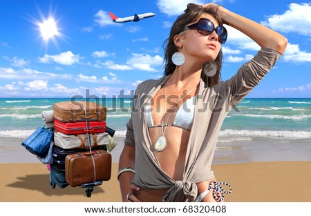 Young woman in bikini on the beach with suitcases and airplane on background