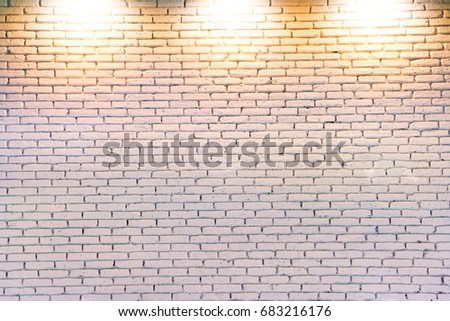 white brick wall under three spot lights