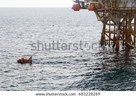 Small boat or fast rescue craft leaving offshore production platform at oil field