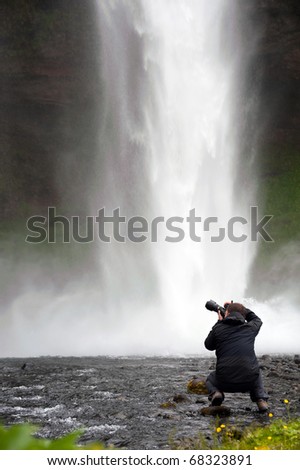photographer taking picture of Seljalandsfoss waterfall, Iceland