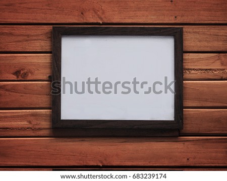 Blank wooden photo frame on wooden panels background