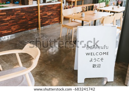 welcome sign on cafe with  thai english japanese and chinese language
