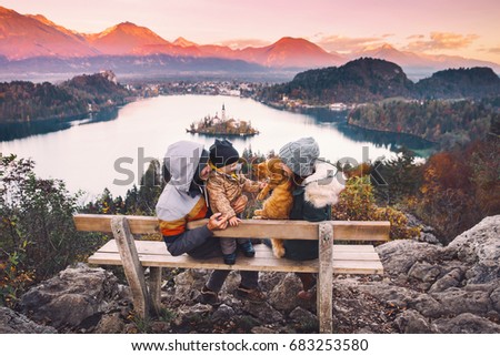 Family travel Europe. Bled Lake at autumn or winter time, Slovenia, Europe. Top view on Island with Catholic Church in Bled Lake with Castle and Mountains in Background.