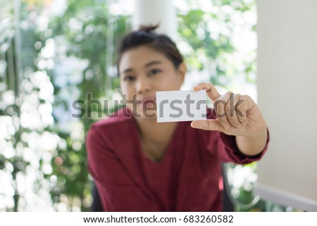 business women holding white business card with blur long glass windows conference room background. copy space for text or business information.