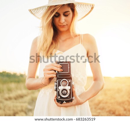 Close up of young woman photographer in dress with vintage camera