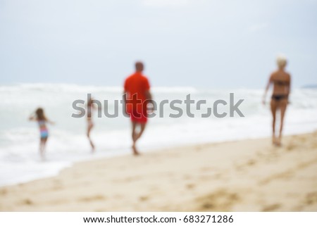 Intentionally out of focus image with family walking barefoot on the beach
