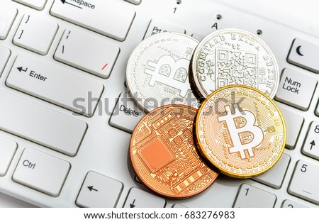 Bitcoin coins gold and silver on white keyboard background