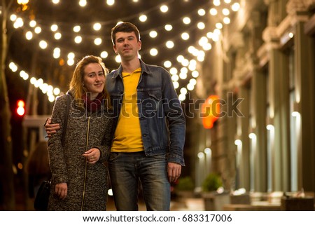 Outdoor portrait of young beautiful happy smiling couple posing on street.